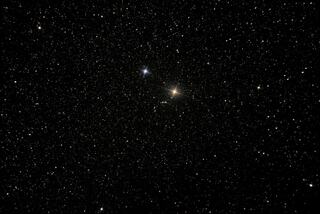 A vast expanse of black space filled with countless stars, some twinkling brightly against the dark backdrop of the cosmos.