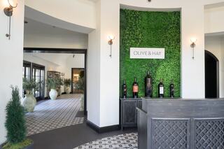 Stylish entrance with a green wall feature, featuring wine bottles and elegant decor, creating a welcoming ambiance for guests.